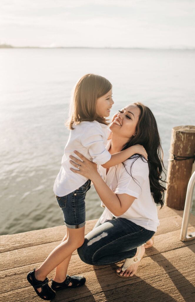 mom and daughter standing on a pier